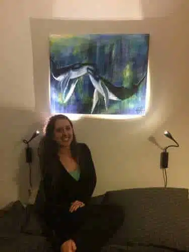 Maleri på bestilling af to pukkelhvaler. kvinden i sofaen under maleriet har fået maleriet som gave.