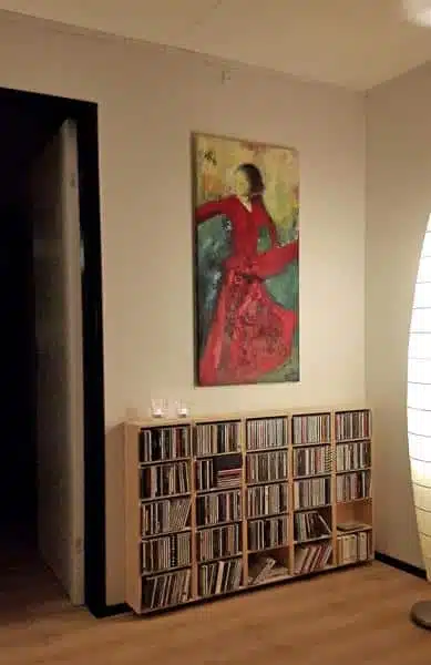 solgt maleri af rød flamencodanser på væggen over bogreol