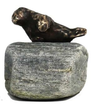 Sæl som bronzefigur på sten