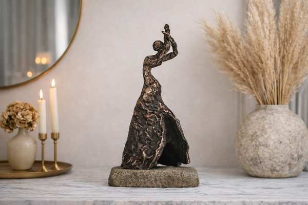Bronzeskulptur af flamencodanser på et marmorbord foran spejl