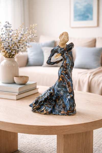 Glaseret keramikskulptur af flamencodanser. Den er placeret på et sofabord, og farven i glacuren går igen i noget af interiøret